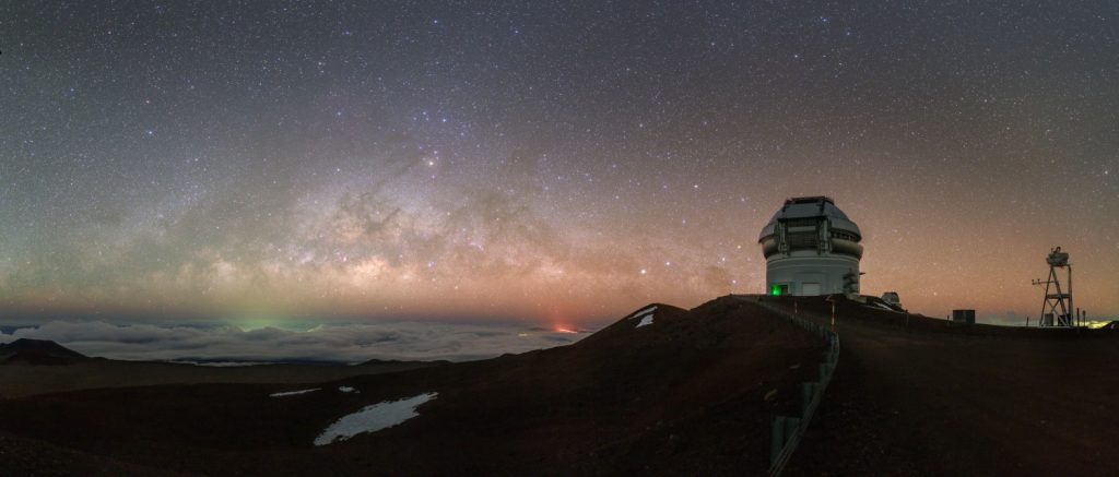 Centrum Mléčná dráhy nad oblačnou "peřinou" nad Tichým oceánem, vpravo teleskop Gemini North. Foto: Petr Horálek.