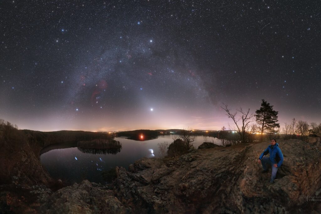 Kužel zvířetníkového světla sahající až k oblouku Mléčné dráhy v březnu 2020 (jasný objekt je planeta Venuše). Na obzoru bohužel září také světelné znečištění z měst, kvůli kterému je pozorování zvířetníkového světla čím dál obtížnější. Foto: Petr Horálek.